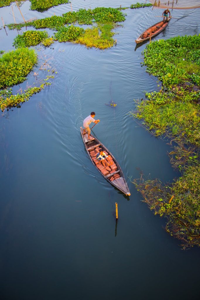 two person riding black wooden boats